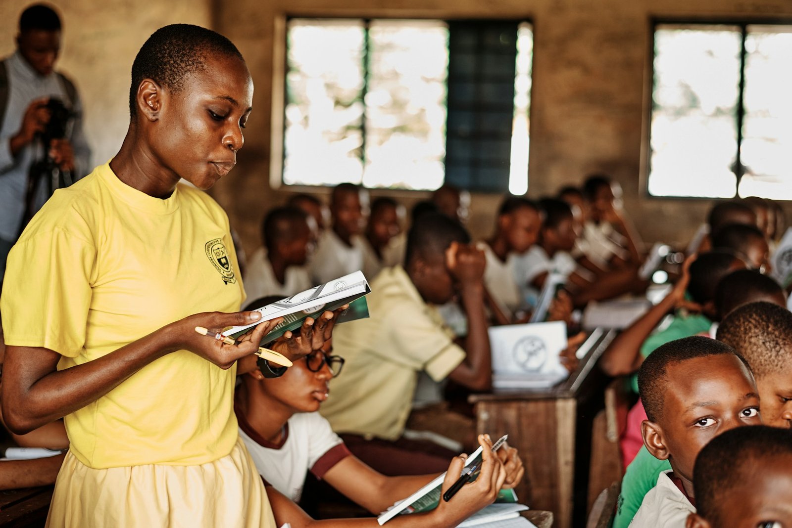 A woman standing in front of a group of children in Ghana